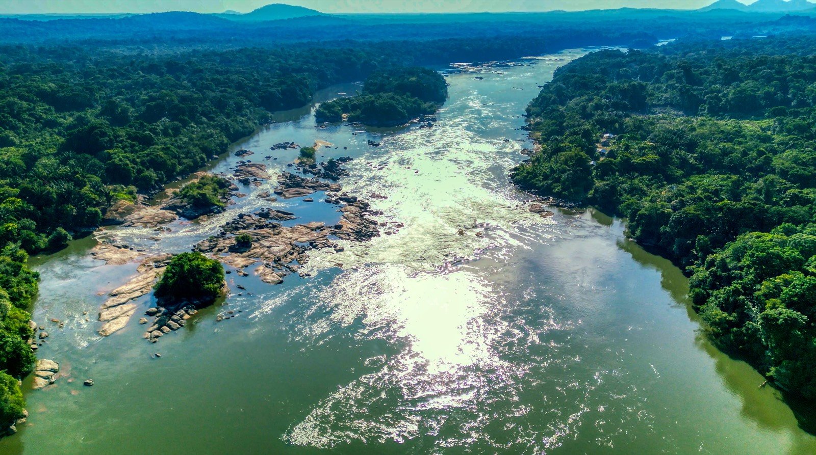 Aerial view of a free-flowing river with rocky rapids and intact forest in the Colombian Amazon