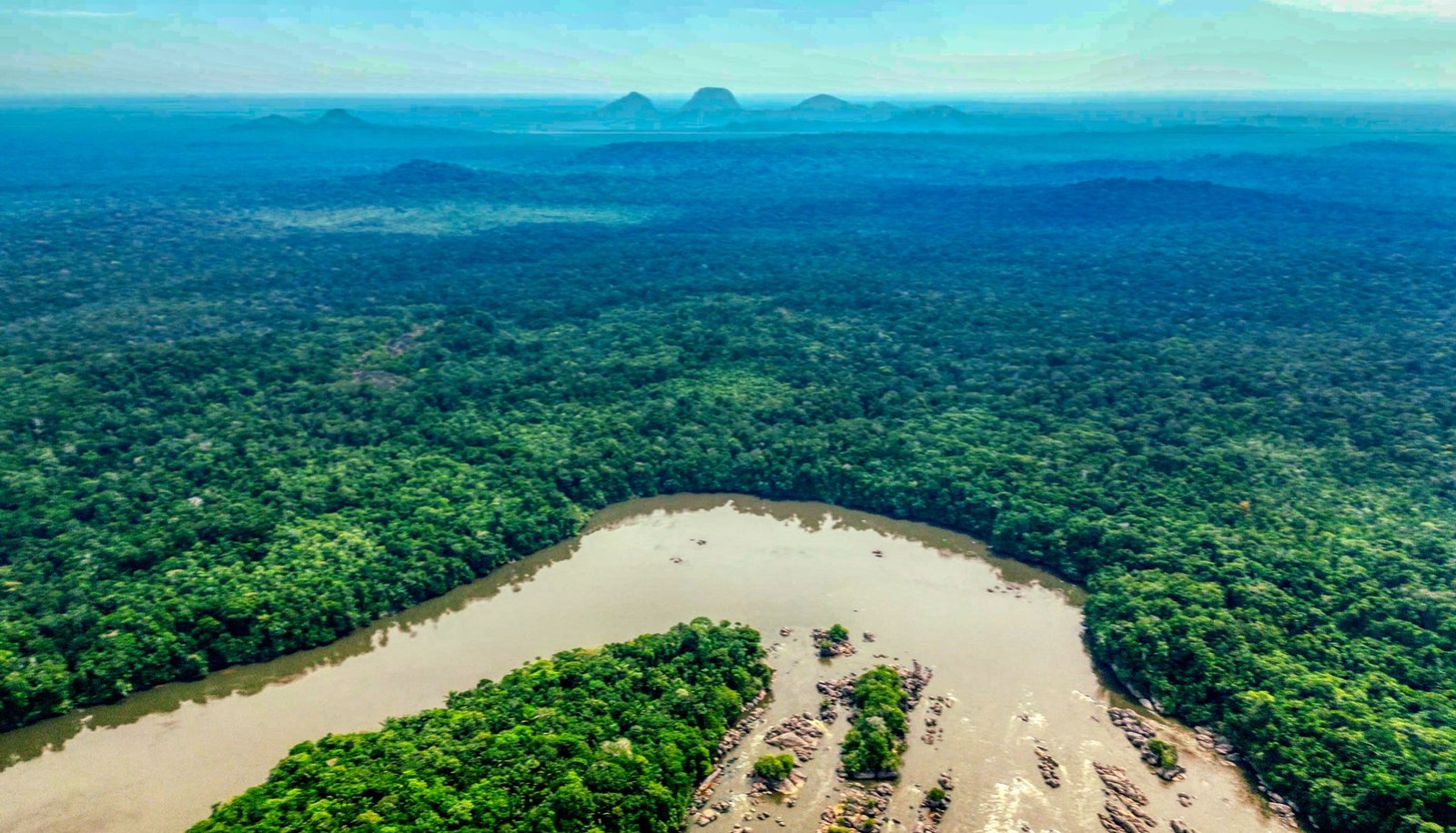 Forested cerros rising in the distance over the Colombian Amazon